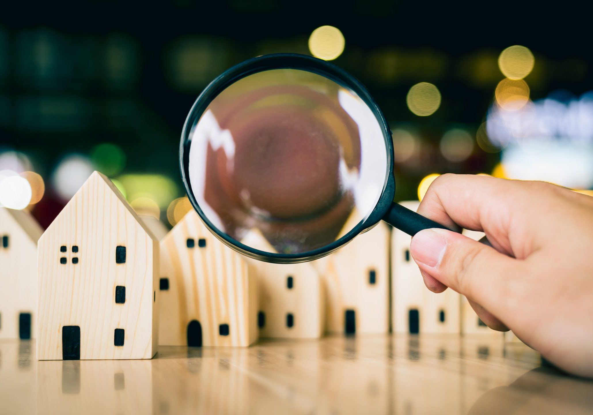 Magnifying glass for looking at house model, house selection, real estate concept.